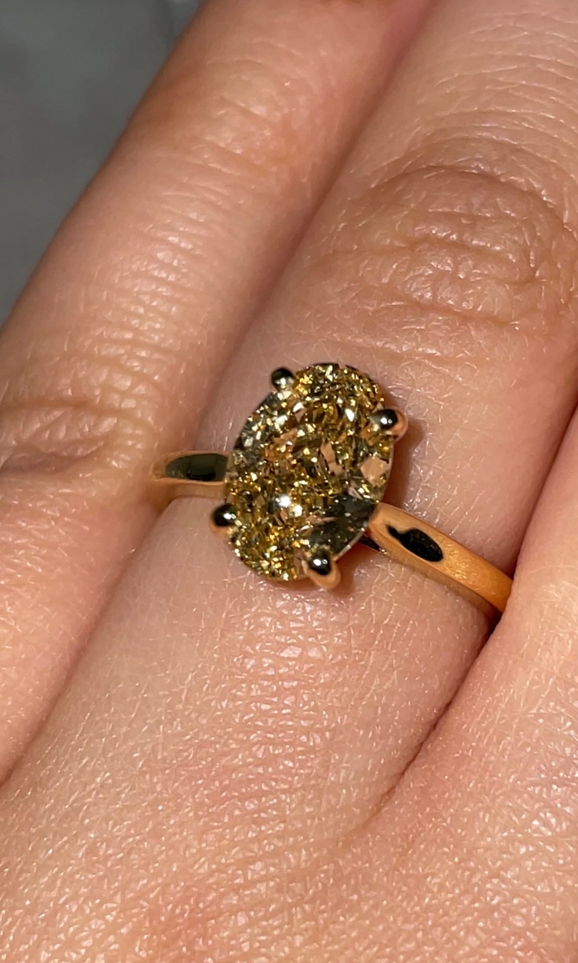 A 2ct oval-cut fancy vivid yellow diamond ring set in a solitaire 18k yellow gold band